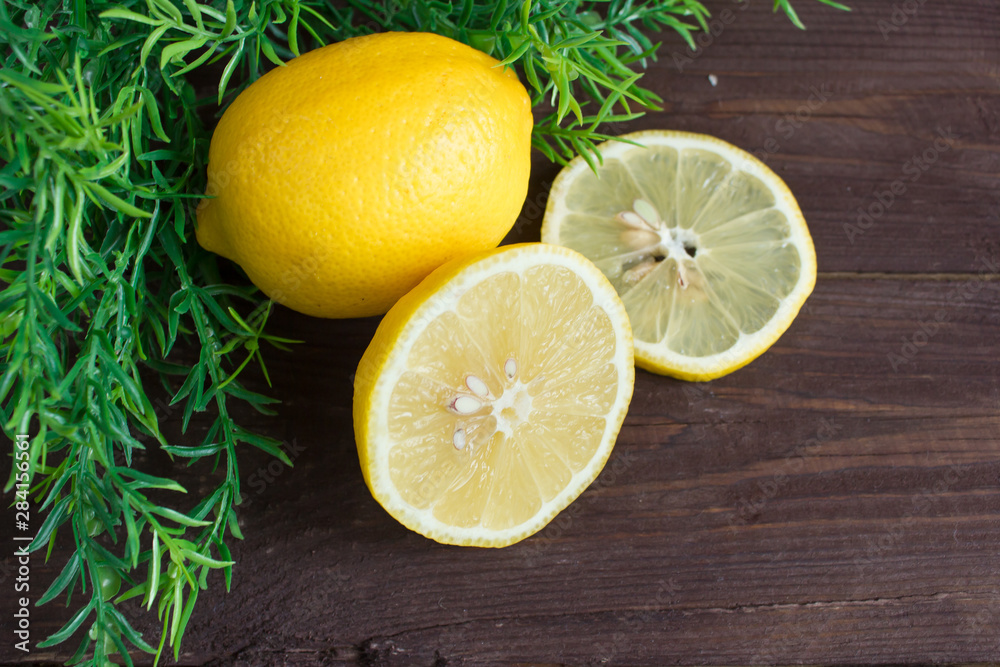 Lemon slices over a wooden background with a green sprig Lemon slices over a wooden background with a green sprig