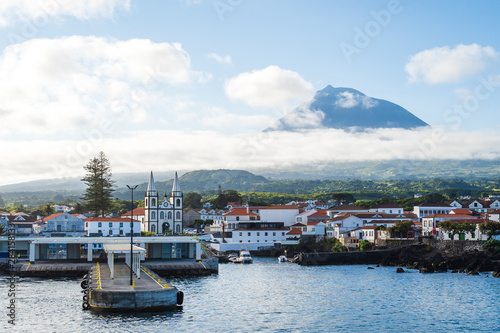 The church and city of Madalena against the Pico Volcano Mountain and blue sky, Pico Island, Azores Islands, Portugal photo