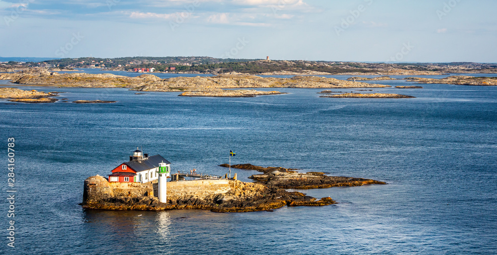 Small rocky outcrop with lighthouse, beacon in the Kattegat sea off the coast of Gothenburg, Sweden on 26 July 2019 Small rocky outcrop with lighthouse, beacon in the Kattegat sea off the coast of Gothenburg, Sweden on 26 July 2019