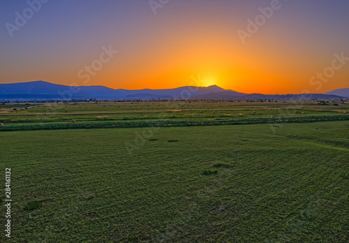 Aerial view of the fields near Sinj countryside and the sun touching horizon