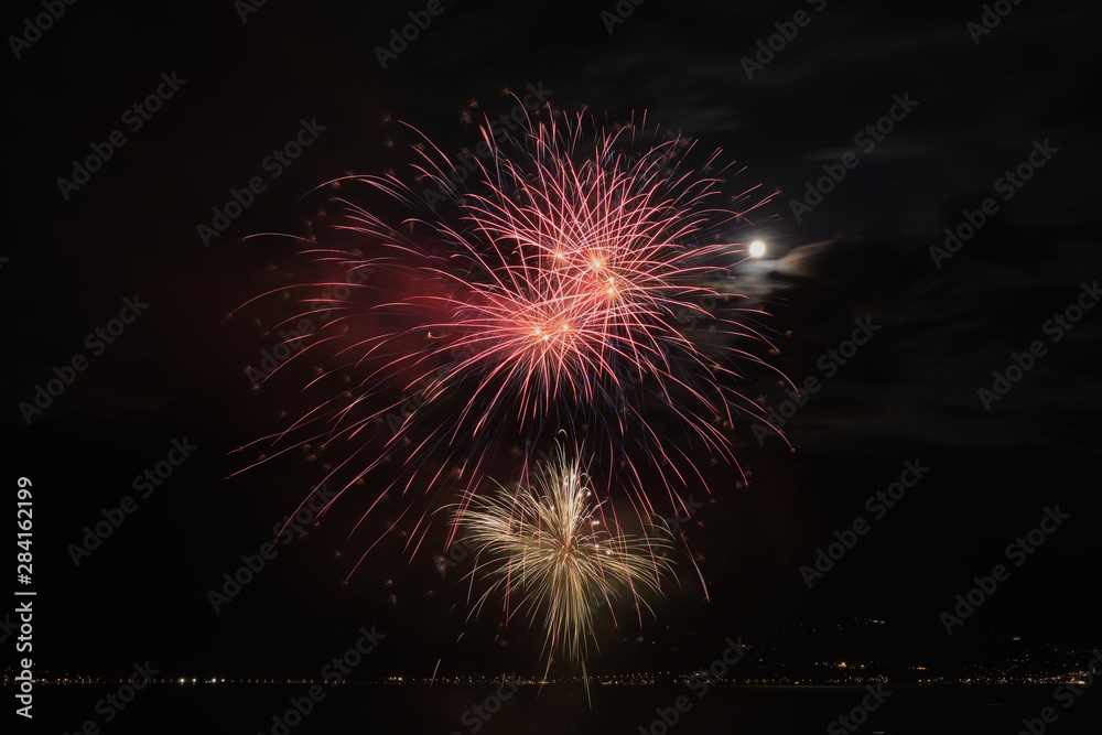 Firework show on Lake Garda. In the city of Limone Sul Garda Italy. Aerial view. Long and charming evening Yellow Night.
