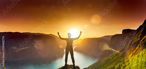 Silhouette einer Frau bei Sonnenuntergang am Aurlandsfjord