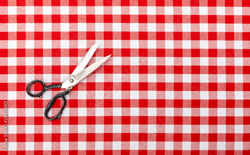 Alte Schneiderschere auf karierter Tischdecke