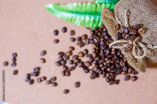 Close up coffee beans and Blur coffee beans in coffee burlap bag on old wooden background. Copy space for text.