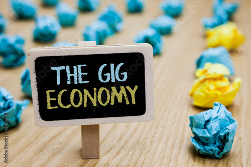 Conceptual hand writing showing The Gig Economy. Business photo text Market of Short-term contracts freelance work temporary poster board with blurry paper lobs laid serially mid yellow lob