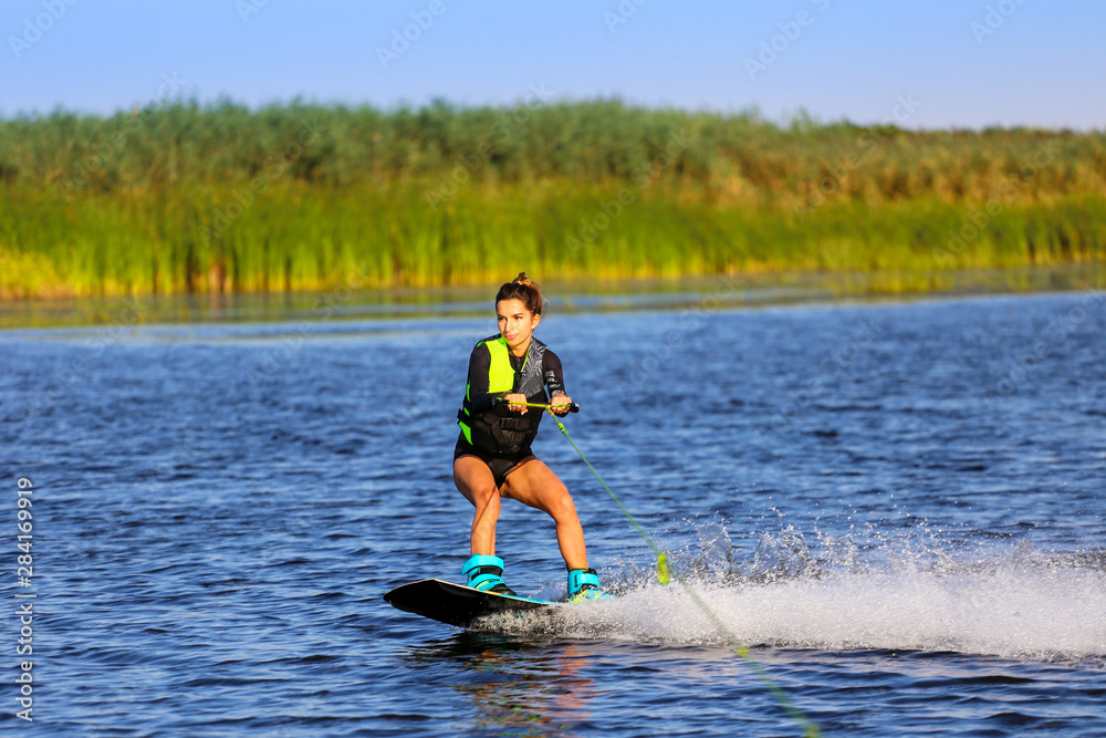 Young Sexy girl Catch waves on wakeboard when boat pulls a wakeboard Photos  | Adobe Stock
