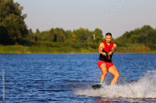 Fototapeta Naklejka Na Ścianę i Meble -  Man making waves on wakeboard 