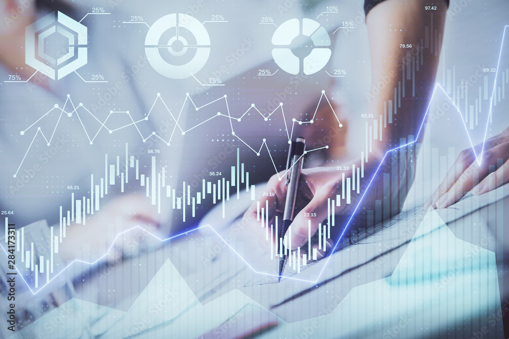 A woman hands writing information about stock market in notepad. Forex chart holograms in front. Concept of research. Double exposure A woman hands writing information about stock market in notepad. Forex chart holograms in front. Concept of research. Double exposure