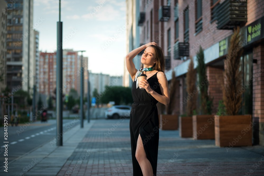 Young beautiful girl with coffee in the street. Warm toning Young beautiful girl with coffee in the street. Warm toning