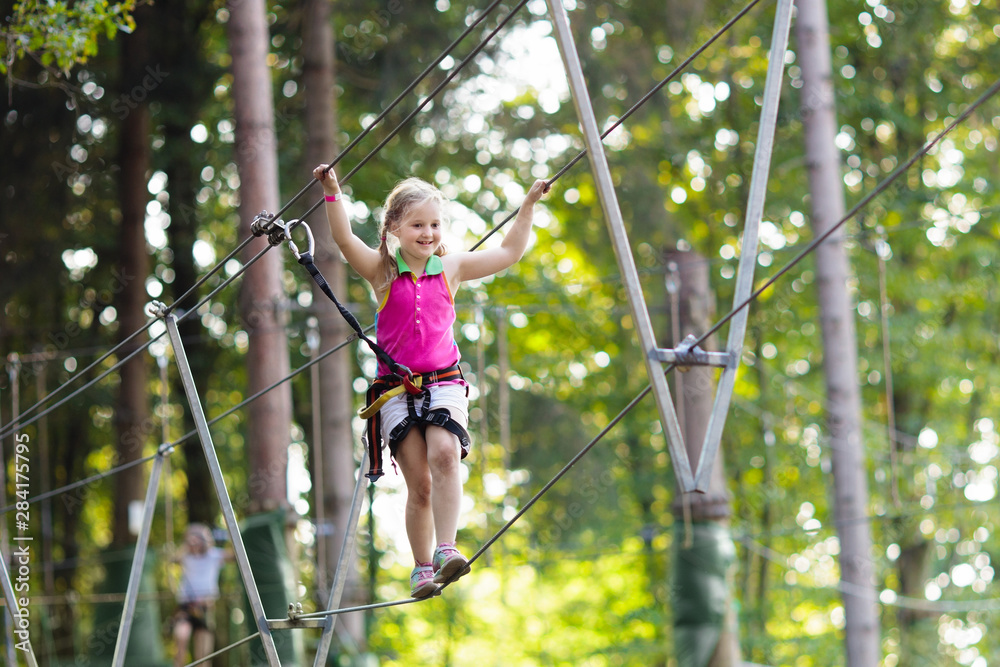 Child in adventure park. Kids climbing rope trail. Child in adventure park. Kids climbing rope trail.