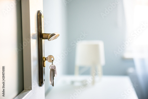 Bright Hi photo of keys in the door's lock. Relocation, housing estate concept. New construction property, white raw scandinavian style.