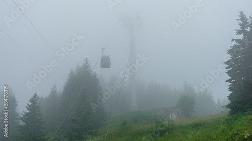 Cable car up in the sky in the forest in Sinaia, Romania, mountain view in rainy summer day