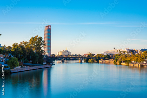 Long exposure of Torre Sevilla and bridge crossing the Canal de Alfonso XIII, Seville, Spain photo