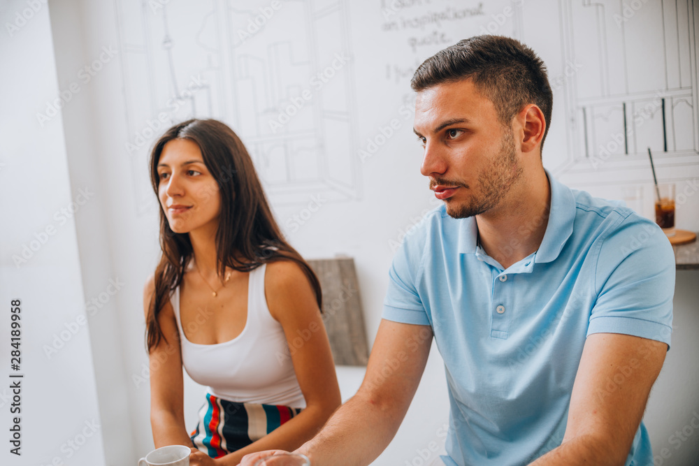 Fototapeta premium Cheerful couple drinking wine in cafe and having conversation