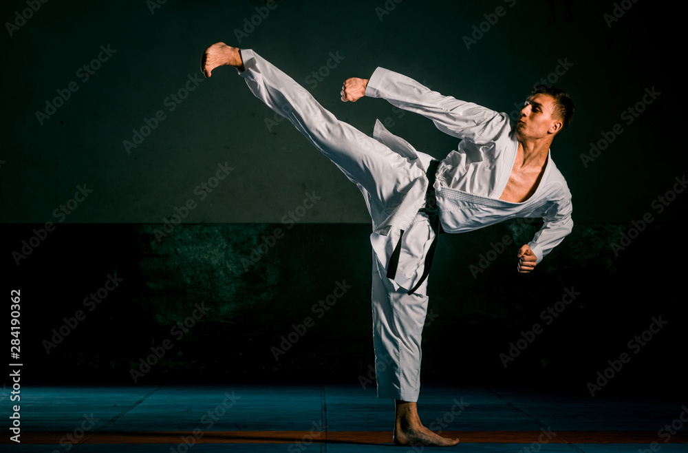 Karate martial arts fighter in white kimono in the gym