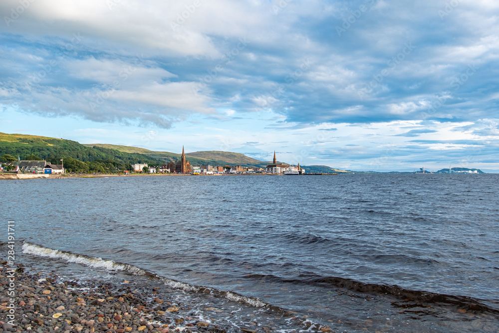 Scottish Town of largs Looking Across the Bay to the Town before sunset as the as the sun relects on the sky and the town.