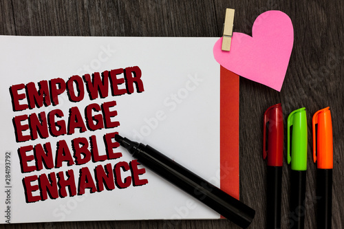 Writing note showing Empower Engage Enable Enhance. Business photo showcasing Empowerment Leadership Motivation Engagement Bold red words pen on page small heart corner pens laid serially photo