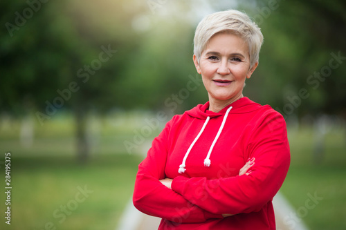 beautiful elderly woman with short haircut goes in for sports in the park