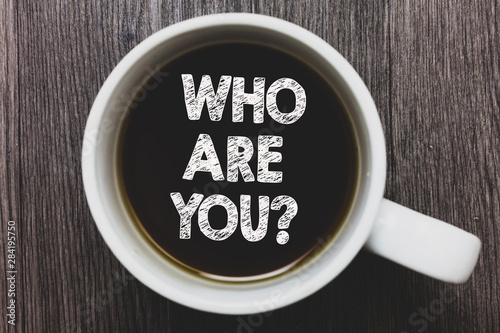 Word writing text Who Are You question. Business concept for Identify yourself description personal characteristics Black coffee with coffee mug floating texts on gray black wooden desk photo