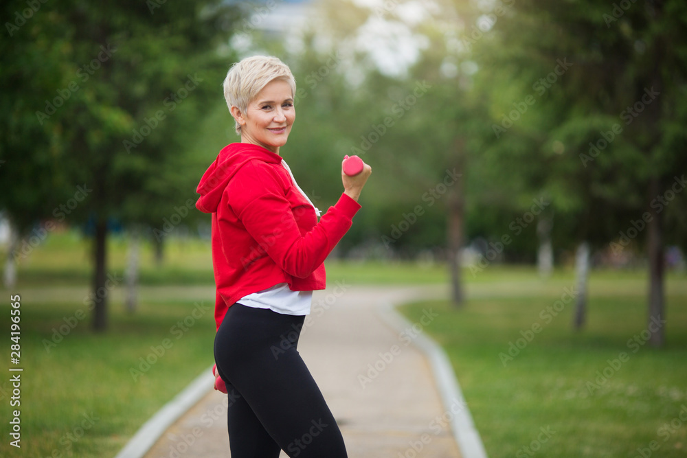 beautiful elderly woman with short haircut goes in for sports in the park beautiful elderly woman with short haircut goes in for sports in the park