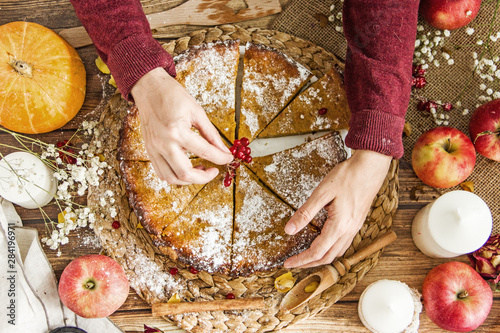 Crop person eating tasty apple and pumpkin pie From above anonymous person taking piece of delicious apple and pumpkin pie with berries over wooden table