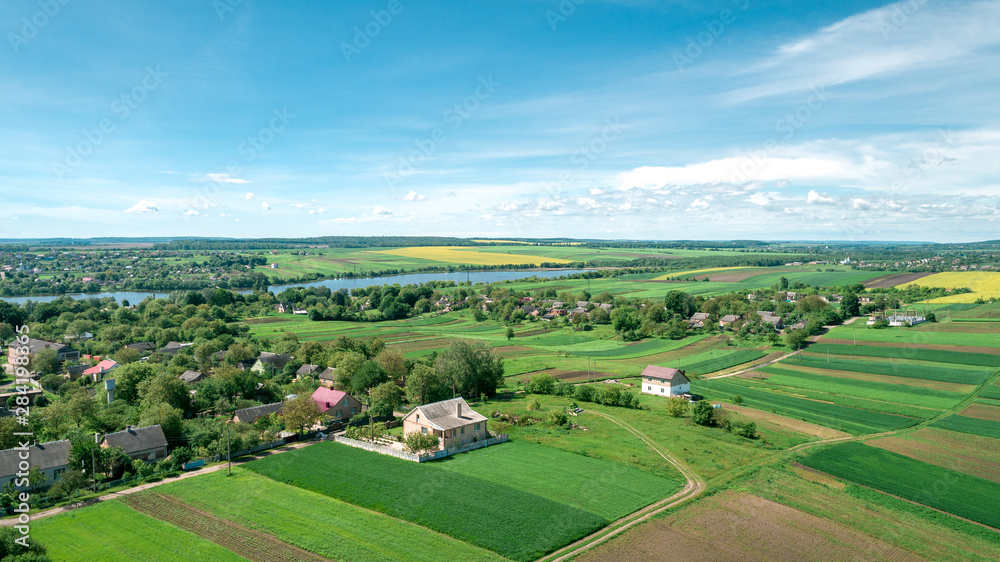 Top view of rural landscape on sunny spring day. House and green field. Drone photography