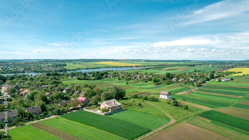 Top view of rural landscape on sunny spring day. House and green field. Drone photography