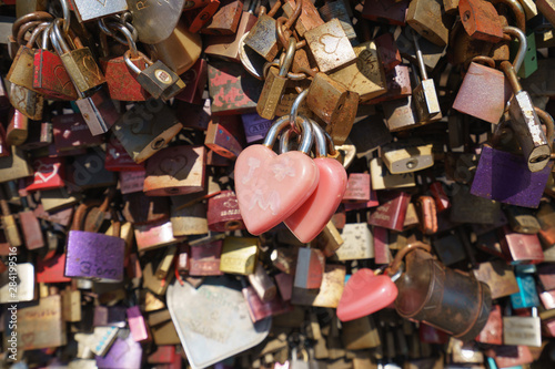 Photo of love locks. Lovers hang licks on a bridge in the city. Natural bright background.