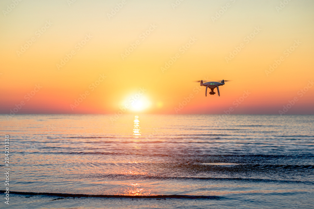 flying drone on a background of sea sunset