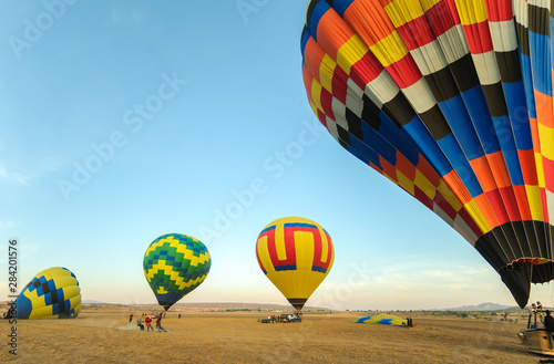 Colorful hot air balloon with blue sky taking off at sunrise
