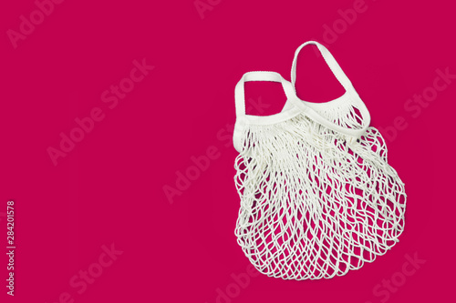 Empty eco bag isolated on a bright pink background