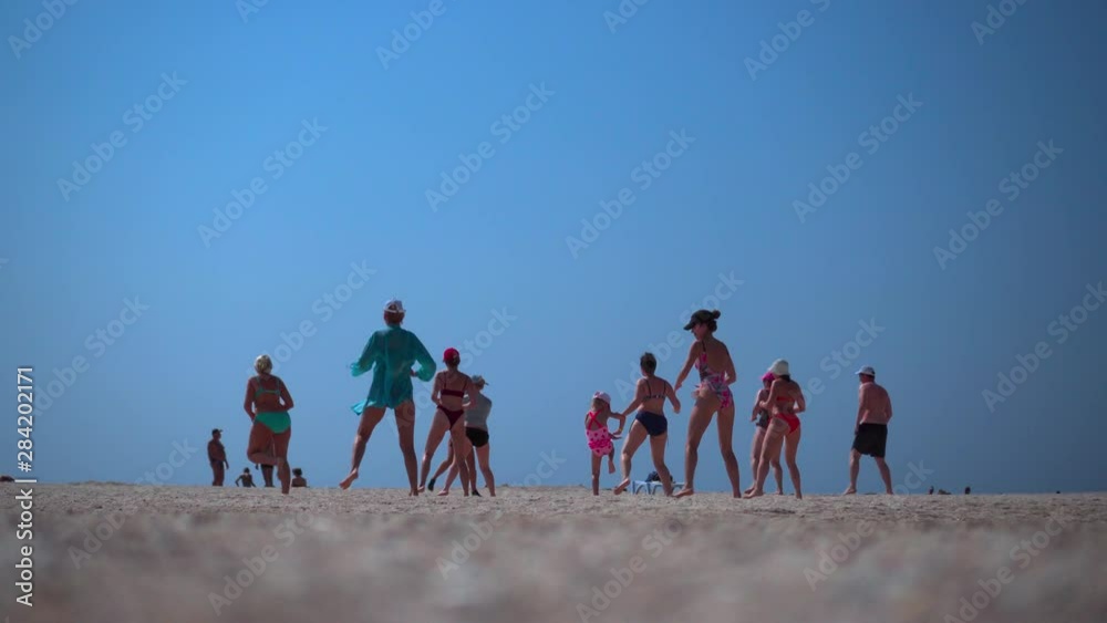 A group of people doing fitness on the beach. Aerobics. Healthy lifestyle, losing weight. A group of people doing fitness on the beach. Aerobics. Healthy lifestyle, losing weight.
