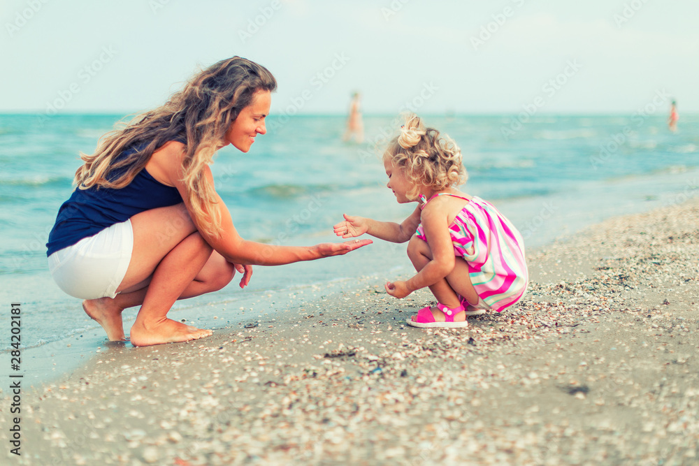 happy mother and daughter playing on sea vacation happy mother and daughter playing on sea vacation