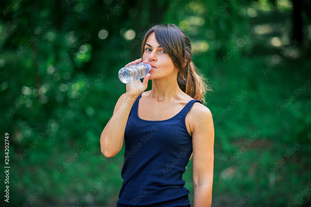 a girl drinks water after sport a girl drinks water after sport