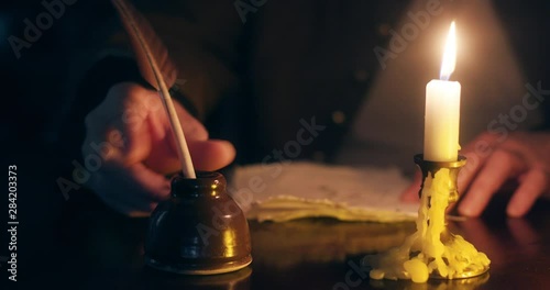 1700s man writing with a quill pen on handmade paper photo