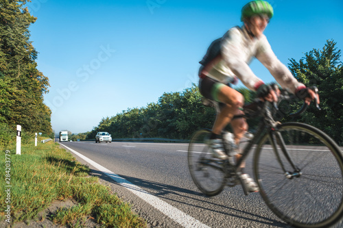 Blurred image of cyclists athletes racing at high speed on the highway