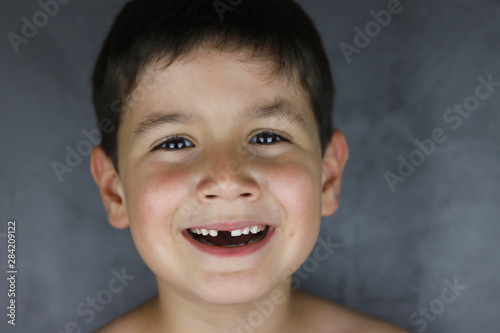 niño feliz que ha perdido un diente de leche photo