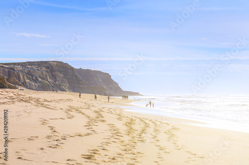 People relaxing and walking on the ocean beach in a shine bright light  at sunny day. Wonderful romantic seascape of ocean coastline.