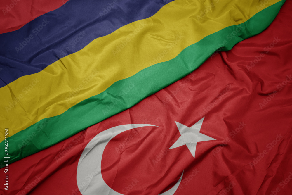 waving colorful flag of turkey and national flag of mauritius.