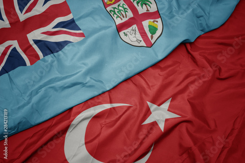 waving colorful flag of turkey and national flag of Fiji.