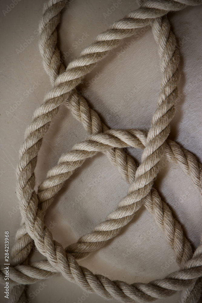 natural hemp rope coiled on a beige floor