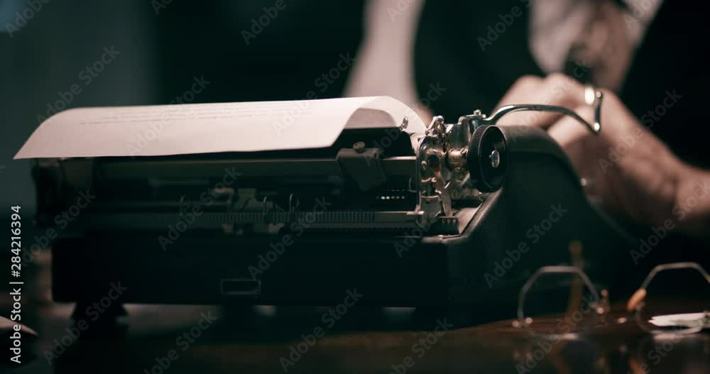closeup of a vintage man using a typewriter