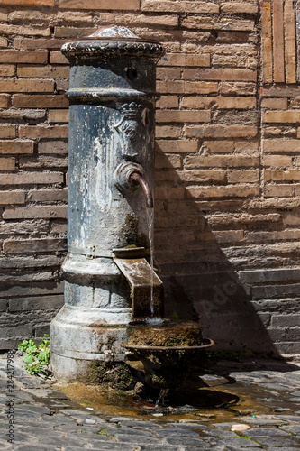 Typical antique public drinking fountain on the streets of Rome