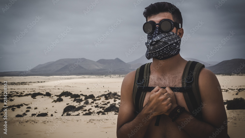 Desert man with handkerchief on his face and sand goggles