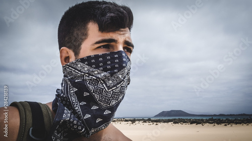 Desert man with handkerchief on his face and sand goggles. Halloween concept.