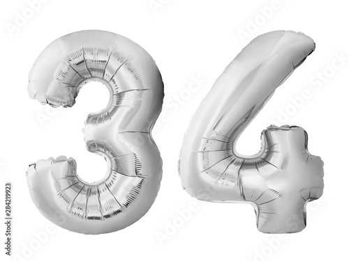 Number 34 thirty four made of silver inflatable balloons isolated on white background. Chrome silver helium balloons forming 34 thirty four. Birthday concept photo