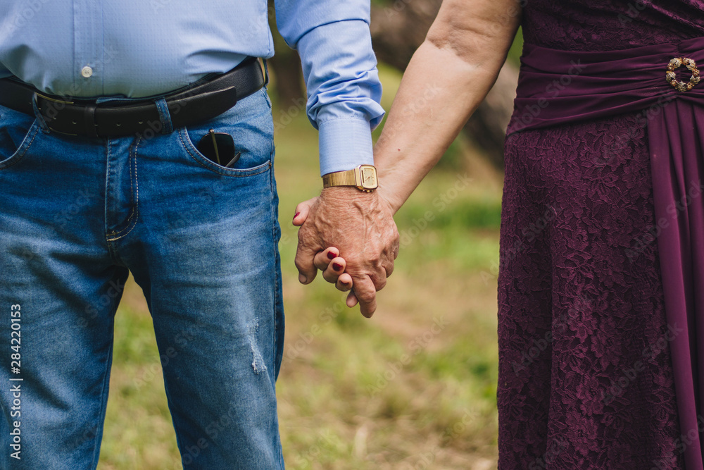 elderly couple holding hands