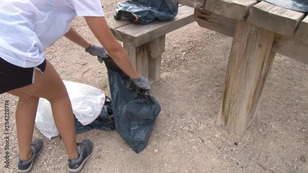 Young Female Volunteers Clean Polluted nature from plastic trash near the river. Young Female Volunteers Clean Polluted nature from plastic trash near the river.