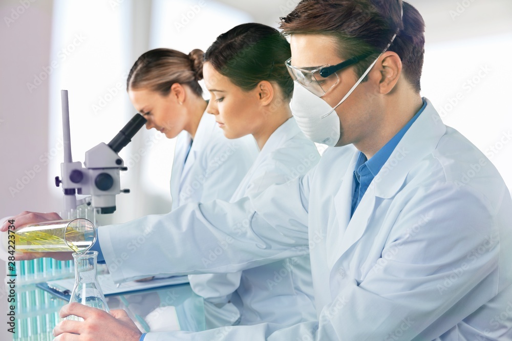 Young male scientist Working with Microscope Young male scientist Working with Microscope