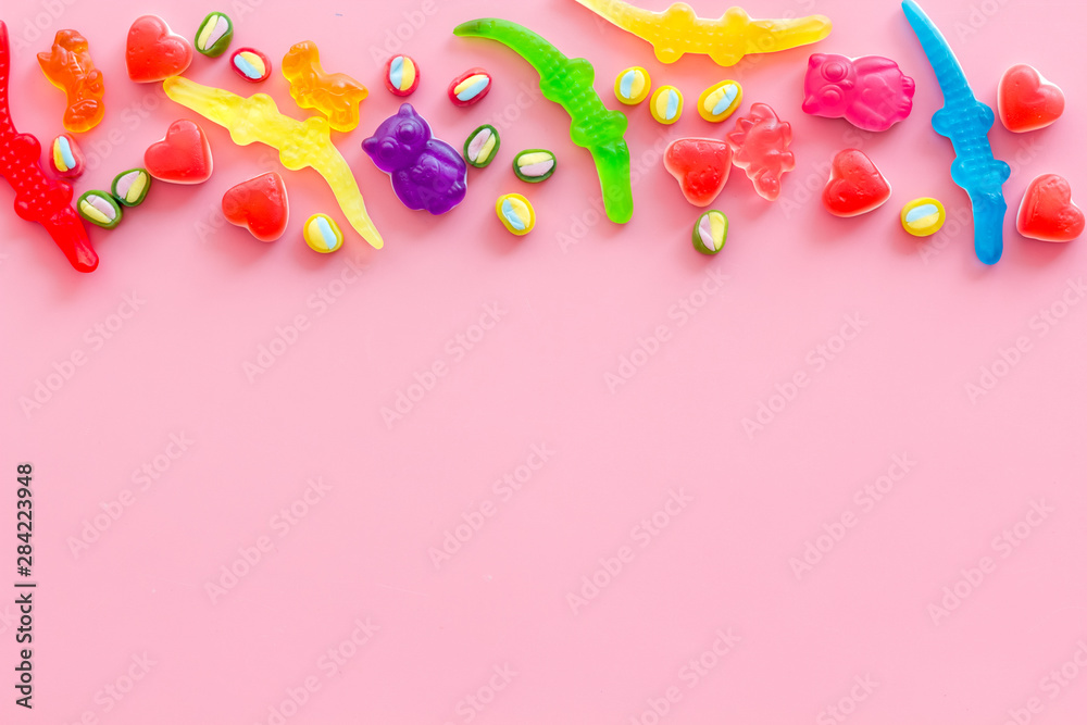 Assorted sweets and marmalade on pink background top view space for text